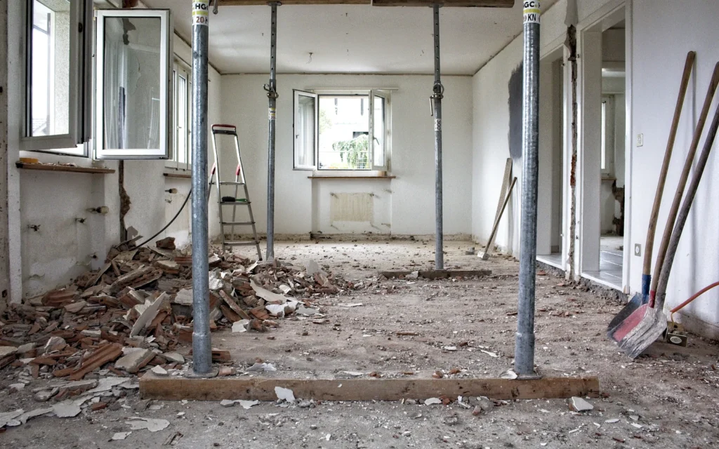 Adjustable steel shoring posts holding up a concrete ceiling while structural repairs are carried out