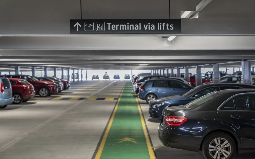 Cars parked between concrete columns on a multi-level parking garage deck, the kind of structure a Local Law 126 inspection covers